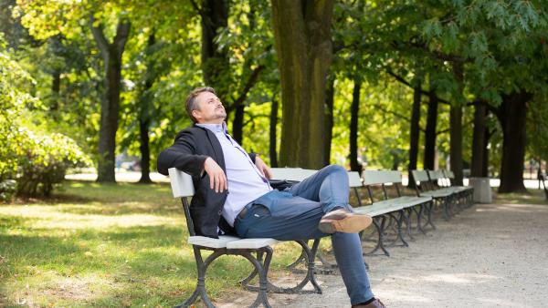 The man on the bench catches the rays of the sun