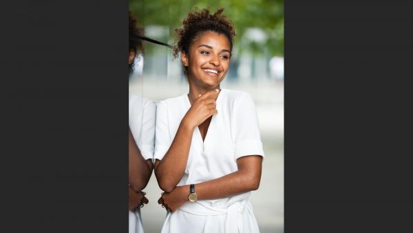 Happy young woman next to mirror wall